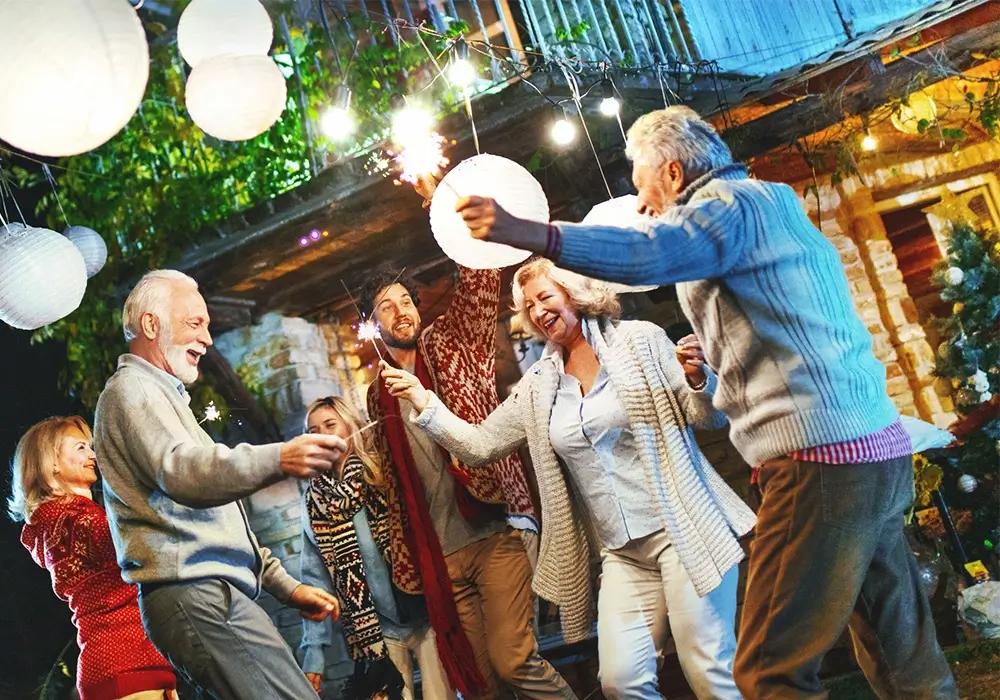 En gruppe på seks personer av ulik alder og kjønn som danser, smiler og nyter livet.