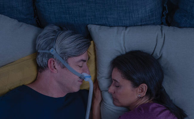 menneske sove-med-AirFit-N30-CPAP-maske-nær-til-sin-kone-mobile