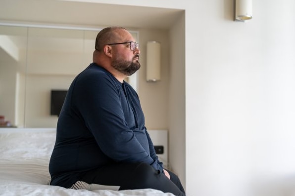  Rastløs mann sitter i sengen