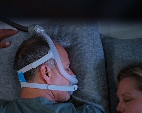 sleep-apnea-pasient-sove-på-seg-magen-med-AirFit-F30i-maske-mobile Resmed-Norge